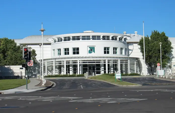 The consensus reading of AMD is that it is winning the accelerator war slowly and the only question is how much share it takes from Nvidia. That framing misses where the money is actually going. AMD closed at <strong>$477.57</strong> on 4 September 2026, up 4.69%, and guided third-quarter gross margin to <strong>approximately 56%</strong> - identical to the 56% it had just delivered - on revenue guided <strong>13% higher sequentially</strong> and into the richest product mix the company has ever shipped. Instinct accelerators and Helios racks carry AMD's highest selling prices in its history. A mix shifting toward them should lift blended margin mechanically. The guide says it will not. Something is absorbing that margin before it reaches AMD's income statement, and it is not Nvidia.
It is memory. In the same window that AMD's gross margin sat pinned at 56%, <a href="https://financefeeds.com/micron-mu-stock-prediction-1500-bull-560-bear/">Micron's went from 37.7% to 84.6%</a> and its guidance calls for roughly 86%. These are not two separate stories about two semiconductor companies. They are one story told from opposite ends of the same bill of materials. High-bandwidth memory is consumed per accelerator, it is supply-constrained, and its price is set by a supplier with pricing power that AMD does not currently have over its own customers. The memory makers are taxing the accelerator makers, and AMD's flat margin guide is the receipt. That is the fact that should drive an AMD valuation, and it is almost entirely absent from the sell-side framing of the stock.
Key facts
AMD closed at <strong>$477.57</strong> on 4 September 2026, up 4.69%, and 17.8% below its 52-week closing high of $580.91 - <a href="https://stockanalysis.com/stocks/amd/">stockanalysis.com daily closes</a>, retrieved 5 September 2026
Second-quarter 2026 revenue was a record <strong>$11.5bn, up 50% year on year</strong>, with GAAP gross margin of 54% and non-GAAP gross margin of 56% - <a href="https://www.sec.gov/Archives/edgar/data/2488/000000248826000121/q22026991.htm">AMD Q2 2026 results, 4 August 2026</a>
Data Center revenue <strong>more than doubled year on year and reached 58% of total company revenue</strong> - same filing
Third-quarter guidance is revenue of <strong>approximately $13bn plus or minus $300m</strong>, about 41% year-on-year growth, with non-GAAP gross margin of <strong>approximately 56%</strong>, unchanged sequentially - same filing
GAAP net income was <strong>$2.3bn</strong> on diluted EPS of $1.38; non-GAAP EPS was $1.66 - same filing
On 17 August 2026 AMD closed a <strong>four-tranche senior notes offering</strong> maturing 2029, 2031, 2033 and 2036, underwritten by Barclays, BofA Securities, Citigroup, J.P. Morgan, Morgan Stanley and Wells Fargo - <a href="https://www.sec.gov/Archives/edgar/data/2488/000119312526354029/d142696d8k.htm">AMD Form 8-K, 17 August 2026</a>
Research and development ran <strong>$2.53bn in the quarter, 21.9% of revenue</strong> - AMD Q2 2026 Form 10-Q, filed 5 August 2026 (FinanceFeeds calculation)
What is actually happening inside the margin line
AMD's second quarter was, on its own terms, excellent. "We delivered an excellent quarter, with record revenue and profitability as Data Center revenue more than doubled year-over-year," said <strong>Dr Lisa Su, AMD chair and chief executive</strong>, in the results release. "We enter the second half with strong momentum as EPYC demand accelerates, Instinct deployments scale and Helios begins to ramp."
The composition matters more than the total. <strong>Jean Hu, AMD executive vice president, chief financial officer and treasurer</strong>, put the concentration plainly: "Revenue increased 50% year-over-year to a record $11.5 billion, driven by continued strength in our Data Center business, which represented 58% of company revenue in the quarter."
So a majority of AMD's revenue now comes from a segment that grew more than 100% year on year, and the blended gross margin still will not move. There are only three explanations. Either the data-centre products carry a lower gross margin than the corporate average, which would be surprising given their pricing. Or input costs are rising fast enough to offset the mix benefit. Or AMD is discounting to win placements. The memory-cost evidence points hard at the second, and we have separately <a href="https://financefeeds.com/nvidia-nvda-ai-server-price-hike-memory-costs/">documented Nvidia raising AI server prices by more than 15% specifically on memory costs</a>, which tells you the pressure is industry-wide rather than an AMD execution failure.
The distinction matters enormously for the valuation. An execution problem is fixable by AMD. A structural transfer of margin to the memory suppliers is fixable only when memory supply loosens, which is outside AMD's control and, on current industry capacity plans, unlikely before calendar 2027.
The balance sheet just changed character
On 17 August 2026 AMD closed a four-tranche senior notes offering maturing in 2029, 2031, 2033 and 2036, executed through a Third Supplemental Indenture and underwritten by six of the largest banks on Wall Street. The filing is signed by Jean Hu as chief financial officer.
The interesting part is that AMD did not obviously need the money. This is a company generating billions in quarterly operating cash flow with a modest debt load by megacap standards, and the stated use of proceeds is the standard general-corporate formula rather than a named acquisition or project. A company in that position raising multi-billion-dollar term debt across four maturities is doing one of two things: pre-funding a capital commitment it has not yet announced, or insuring against a capital market that might be less friendly in eighteen months.
Either reading is a change in character for a business whose entire structural advantage over <a href="https://financefeeds.com/intel-intc-stock-prediction-135-bull-case-vs-48-bear-case/">Intel</a> was being asset-light. AMD outsources fabrication to <a href="https://financefeeds.com/tsmc-tsm-stock-prediction-610-bull-case-vs-265-bear-case/">TSMC</a> precisely so that it does not carry the capital intensity that has crushed Intel's returns. Adding term debt narrows that distinction at the margin, and it does so at coupons set in a higher-rate world than the one in which AMD's existing paper was issued.
The valuation, stated honestly
There is no reading of AMD that makes it cheap. Annualise the second-quarter GAAP diluted EPS of $1.38 and you get roughly $5.52; against $477.57 that is about <strong>87 times GAAP earnings</strong> (FinanceFeeds calculation). Annualise the non-GAAP $1.66 and you get $6.64, or about <strong>72 times</strong>. With approximately 1,632.5 million shares outstanding as of the Q2 10-Q cover date, the market capitalisation is roughly <strong>$780bn</strong>.
This is the single most important thing for a reader to internalise: <strong>the bear case for AMD is not a business failure, it is a re-rating.</strong> Even at $310, a 35% decline from spot, AMD would trade at roughly 47 times annualised non-GAAP earnings. That is still a growth multiple. The stock does not need anything to go wrong operationally to fall by a third; it only needs the market to decide that 70 times is the wrong number for a company whose gross margin will not expand.
ScenarioLevelWhat has to be true
<strong>Bull</strong><strong>$700</strong>Gross margin breaks above 56% as memory supply loosens or AMD reprices, Instinct wins a second hyperscaler at scale, and the market keeps paying a premium multiple for accelerating data-centre share
<strong>Base</strong><strong>$540</strong>Revenue compounds toward the guided $13bn quarterly run-rate and beyond, margin stays near 56%, and the multiple slowly compresses as growth is delivered rather than anticipated
<strong>Bear</strong><strong>$310</strong>Margin stays pinned, the AI capital-expenditure cycle shows any sign of digestion, and the multiple resets to roughly 47x - no operational failure required
The research spending nobody is comparing
Put AMD's income statement beside Micron's and one line separates them more sharply than revenue, margin or growth. AMD spent <strong>$2.53bn on research and development in the quarter, equal to 21.9% of revenue</strong>. Micron, in its most recent reported quarter, spent <strong>$1.32bn, equal to 3.2% of revenue</strong> (FinanceFeeds calculations from each company's Form 10-Q).
AMD is spending nearly seven times as much of every revenue dollar on engineering as the company capturing the margin. That is not an indictment of AMD's spending, which is what buys the roadmap that produced 50% revenue growth. It is an observation about where economic rent is accruing in this cycle, and the answer is uncomfortable for anyone holding accelerator equities: the returns are landing with the supplier that is capacity-constrained, not the designer that is innovation-constrained.
The historical parallel is the personal-computer industry of the 1990s, where the companies designing and assembling the machines competed away their margins while Intel and Microsoft, each a bottleneck, took the profit pool. Bottlenecks earn the rent. In 2026 the bottleneck is not logic design, where AMD, Nvidia and a growing roster of in-house hyperscaler teams all compete. It is memory, where three companies control effectively all supply and are visibly not racing each other to add it.
For AMD the strategic question that follows is whether it can move the bottleneck - through packaging, through architectural efficiency in how much memory a given workload requires, or through securing long-term supply on fixed terms the way its own largest customers are now trying to do with it.
The concentration risk that sits under everything
AMD's data-centre growth is a function of a small number of very large buyers. That is true of every accelerator vendor, and it is the structural feature of this cycle that gets least attention when things are going well.
Concentrated demand cuts in both directions. It delivered the doubling that Lisa Su described, and it means a single customer's decision to pause, re-phase or dual-source has an outsized effect on a quarter. It also transfers negotiating power. When supply of accelerators is scarce, the vendor sets terms. When it is not, the hyperscaler does, and hyperscalers have shown across a decade of infrastructure procurement that they will design their own silicon rather than accept a vendor's margin indefinitely.
Layer the memory constraint on top and the picture sharpens. AMD is squeezed between suppliers with pricing power and customers with the scale and engineering capacity to build alternatives. It is executing extremely well inside that squeeze - the 50% revenue growth is real and the share gains are real - but the squeeze is why 50% revenue growth produced no margin expansion at all.
What happens next
<strong>First, the third-quarter margin print is the whole event.</strong> Revenue of roughly $13bn is close to assured given guidance and visible demand. The number that moves the stock is gross margin. Anything above 56% validates the bull case that the memory tax is temporary. Anything at or below it confirms that a richer mix cannot outrun input costs, and the market will start applying that to 2027 estimates.
<strong>Second, watch for the use of the August debt proceeds.</strong> Multi-billion-dollar raises with no stated purpose get a purpose within two or three quarters. If it turns out to be a large capacity prepayment or a supply-securing commitment, that is a bullish signal about visibility and a bearish one about capital intensity, and investors will have to decide which they weight more.
<strong>Third, memory pricing is now an AMD input worth tracking directly.</strong> The clearest leading indicator for AMD's gross margin over the next four quarters is not AMD's own commentary; it is the contract pricing being set by Micron, SK Hynix and Samsung. We have <a href="https://financefeeds.com/ddr5-prices-are-up-nearly-500-as-hyperscalers-book-2027-supply/">tracked DDR5 contract prices up nearly 500%</a>, and the first quarter in which that curve flattens is the first quarter AMD's margin can expand.
Our numbers: bull <strong>$700</strong>, base <strong>$540</strong>, bear <strong>$310</strong>, against a spot of $477.57. What would change our mind on the bear case is a gross-margin print above 57% with memory costs still elevated, which would prove AMD has pricing power it has not yet demonstrated. What would change our mind on the bull case is a hyperscaler publicly committing to in-house silicon for a workload AMD currently serves. For the other side of this trade, our <a href="https://financefeeds.com/nvidia-nvda-stock-prediction-340-bull-135-bear/">Nvidia analysis</a> covers the incumbent whose margins have so far absorbed the same input shock rather better.
Frequently asked questions
<strong>Why is AMD's gross margin not rising when its product mix is improving?</strong>
Because input costs are rising at least as fast as the mix benefit. High-bandwidth memory is consumed per accelerator and its price has risen sharply, with Micron's gross margin going from 37.7% to 84.6% over the same period. AMD guided third-quarter non-GAAP gross margin to approximately 56%, unchanged, despite guiding revenue 13% higher sequentially.
<strong>Is AMD expensive at $477.57?</strong>
On any conventional measure, yes. Annualised second-quarter GAAP EPS of $1.38 implies roughly 87 times earnings, and the non-GAAP figure implies about 72 times. The bear case at $310 still leaves the shares near 47 times annualised non-GAAP earnings, which is why we describe the downside as a re-rating rather than a collapse.
<strong>Why did AMD raise $4.75bn of debt in August 2026?</strong>
The Form 8-K filed on 17 August 2026 documents a four-tranche senior notes offering maturing 2029 through 2036, with the standard general-corporate-purposes language and no named use. AMD generates substantial operating cash flow, so the raise most plausibly pre-funds an unannounced capital commitment or insures against less favourable future funding conditions.
<strong>How concentrated is AMD's data-centre business?</strong>
Data Center represented 58% of total company revenue in the second quarter of 2026 and more than doubled year on year, according to CFO Jean Hu. That concentration is the source of the growth and the main single-quarter risk, because a small number of very large customers control the ordering pattern.
<strong>What is the most important number in AMD's next results?</strong>
Gross margin, not revenue. Revenue of approximately $13bn is well telegraphed by guidance. Whether gross margin breaks above 56% determines whether the memory cost pressure is a temporary tax or a structural feature of this cycle, and that single line drives the 2027 earnings path.
<em>This article is analysis and information, not investment advice. Scenario levels are the author's estimates based on company filings and are not price targets or recommendations. Trading and investing carry risk, including the total loss of capital. Figures were verified against primary sources on 5 September 2026 and may have moved since.</em>