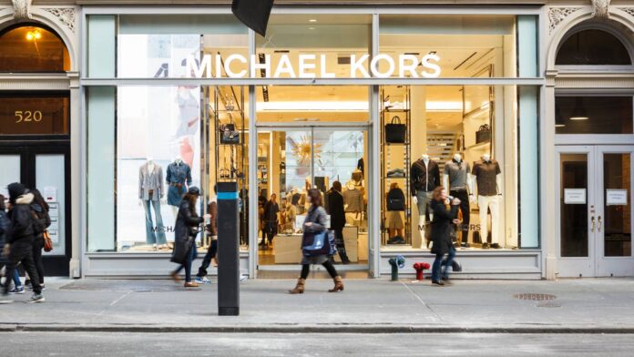 After closing hundreds of stores and offloading a major luxury brand, one of the fashion industry's best-known groups continues to shrink its retail footprint.The move comes as luxury companies navigate a challenging environment marked by softer shopping demand, economic uncertainty, and shifting spending patterns.According to the <a href="https://www.mckinsey.com/industries/retail/our-insights/state-of-fashion">McKinsey & Company State of Fashion 2026 Report</a>, the global fashion industry is projected to grow only in the low single digits in 2026, due to macroeconomic <a href="https://www.thestreet.com/dictionary/v/volatility">volatility</a>, tariff pressures, and weaker consumer sentiment.Now, another iconic luxury group is rethinking its footprint while attempting to strengthen its remaining brands and return to growth.The company began in 1981 as Michael Kors Holdings Limited and changed its name to Capri Holdings Limited in 2018 following its acquisition of Jimmy Choo. It later added Versace to its portfolio before selling the brand to Prada Group in 2025.Capri Holdings closes 41 stores Capri Holdings (<a href="https://www.thestreet.com/quote/CPRI">CPRI</a>) had 871 retail locations as of June 27, 2026, down 41 stores from the 912 it had a year earlier, according to <a href="https://www.modaes.com/global/companies/capri-ends-the-first-quarter-down-but-improves-its-margins-and-sees-a-25-increase-in-earnings">Modaes</a>.The <a href="https://www.thestreet.com/retail/132-year-old-luxury-chain-quietly-closes-more-stores-worldwide-galeries-lafayette">closures</a> included 33 Michael Kors stores and eight Jimmy Choo locations. Michael Kors had 662 stores as of June 27, down from 695 a year earlier, while Jimmy Choo had 209, down from 217.The <a href="https://www.thestreet.com/retail/mall-retail-giant-gap-closes-final-store-oakland-after-26-years">closures</a> come as Capri Holdings experiences uneven performance across its brands. During the first quarter of fiscal 2027, the company reported:Net revenue decreased 3.5% year over year to $769 million.Michael Kors' revenue fell 7.1% to $590 million.Jimmy Choo's revenue increased 10.5% to $179 million.The latest closures continue a recent pattern for the retailer. During the same quarter a year earlier, Capri Holdings closed 79 locations, according to its first-quarter fiscal 2026 <a href="https://s21.q4cdn.com/247539420/files/doc_financials/2026/q1/press-release-080525-vF.pdf">earnings report</a>. The store reductions highlight how Capri Holdings is cutting locations and expenses while <a href="https://www.thestreet.com/retail/claires-piercing-experience-overhaul">investing</a> in its brands, stores, and digital operations to reignite growth.Capri Holdings previously owned Versace, which was acquired by the Prada Group in December 2025 in a cash deal valued at €1.25 billion, or approximately $1.44 billion. The narrower portfolio gives Capri Holdings a more focused approach as it works to <a href="https://www.thestreet.com/retail/ellesse-sportswear-us-comeback-2026">revive growth</a> across its two remaining brands.The deal also marked the <a href="https://www.thestreet.com/retail/luxury-fashion-icon-steps-down-after-nearly-three-decades">end of Donatella Versace's nearly 30-year leadership</a> of the brand.Capri Holdings' new strategy to boost growthAlongside the <a href="https://www.thestreet.com/retail/munich-closing-15-stores-retail-restructuring">closures</a>, Capri Holdings outlined five key priorities to turn around its brands.Strengthen brand appeal through storytelling.Develop fashion that reflects each brand’s heritage while emphasizing <a href="https://www.thestreet.com/retail/lord-and-taylor-revives-heritage-collection">design</a> and innovation.Improve the customer experience across digital and physical channels.Use data analytics to personalize interactions.Invest cash flow in store renovations, technology, and digital improvements, while continuing share buybacks.The strategy comes as the company's two remaining brands follow significantly different trajectories.Capri Holdings expects Jimmy Choo to grow and return to profitability, while Michael Kors continues to face <a href="https://www.thestreet.com/retail/garage-groupe-dynamite-after-closures-fashion-retailer-shifts-strategy">headwinds</a>. The company cited lower-than-anticipated inventory levels in the second quarter, softer trends in EMEA, and updated foreign currency exchange-rate assumptions as factors affecting its outlook.Capri Holdings now expects fiscal 2027 revenue of approximately $3.4 billion, below its earlier expectations. The company lowered its forecast for Michael Kors, while increasing it for Jimmy Choo.Capri Holdings also plans to <a href="https://www.thestreet.com/retail/staples-closing-stores-2026">reduce expenses</a> while maintaining its earnings-per-share outlook of approximately $2.15, representing 40% growth over the prior year."We remain optimistic about Capri Holdings' future," said Capri Holdings CEO John Idol during the company's first-quarter <a href="https://earningscall.biz/e/nyse/s/cpri/y/2027/q/q1">earnings call</a>."Across Michael Kors and Jimmy Choo, we have clear strategies focused on elevating brand desirability, deepening consumer engagement, strengthening product innovation, and improving the quality of our sales."The company's strategy reflects a broader shift among <a href="https://www.thestreet.com/retail/chanel-criminal-trial-hidden-controversial-practice">luxury retailers</a>, who are increasingly reassessing their store portfolios and investing in the brands and shopping experiences they believe can drive stronger sales.
Capri Holdings closes more stores.<a href="https://www.gettyimages.com/detail/1225669850">wdstock / Getty Images</a>
Luxury industry rivals close storesCapri Holdings is not alone in reducing its store footprint. Several major luxury and <a href="https://www.thestreet.com/retail/hm-79-year-old-fast-fashion-retailer-closes-128-stores">retail</a> groups have also closed locations or announced additional shutdowns as they attempt to adjust their businesses to changing consumer demand.The recent moves by other <a href="https://www.thestreet.com/retail/how-companies-have-created-lucrative-empires-following-trends">luxury</a> groups show how widespread the push to reassess physical retail footprints has become.Here's some of <a href="https://www.thestreet.com/author/fernanda-tronco">my previous coverage</a> of store closures:<strong><a href="https://www.thestreet.com/retail/prada-group-versace-store-closures-2026-2027">Prada Group</a>:</strong> Closed 10 Versace stores since the end of 2025 and plans to shutter more locations while relocating select boutiques to stronger markets in 2026 and 2027.<strong><a href="https://www.thestreet.com/retail/luxury-giant-to-close-200-stores-after-sales-drop-kering-retail">Kering</a>:</strong> Closed 133 locations across its brands in 2025, with an additional 100 store closures scheduled worldwide in 2026.<strong><a href="https://www.thestreet.com/retail/159-year-old-retail-giant-announces-more-store-closures-saks">Saks Global</a>:</strong> Plans to close an additional nine stores following the shutdown of hundreds of locations and its <a href="https://www.thestreet.com/dictionary/chapter-11-bankruptcy">Chapter 11 bankruptcy</a> filing.<strong><a href="https://www.businessoffashion.com/articles/luxury/is-ferragamos-turnaround-finally-on-track/">Ferragamo</a>:</strong> Closing roughly 70 stores between 2025 and 2026.<strong><a href="https://www.thestreet.com/retail/170-year-old-luxury-fashion-retailer-quietly-closes-21-stores-burberry">Burberry</a>:</strong> Shuttered 21 locations during fiscal 2026.For Capri Holdings, the latest closures represent more than a reduction in its <a href="https://www.thestreet.com/retail/tractor-supply-petsense-store-closures">physical footprint</a>. They are part of a broader effort to streamline the business, concentrate resources on its remaining brands, and rebuild demand at a time when luxury consumers are becoming more selective about where and how they spend.<strong><a href="https://www.thestreet.com/retail/nike-store-closures-2026">Related: Sportswear giant continues store closures nationwide</a></strong>