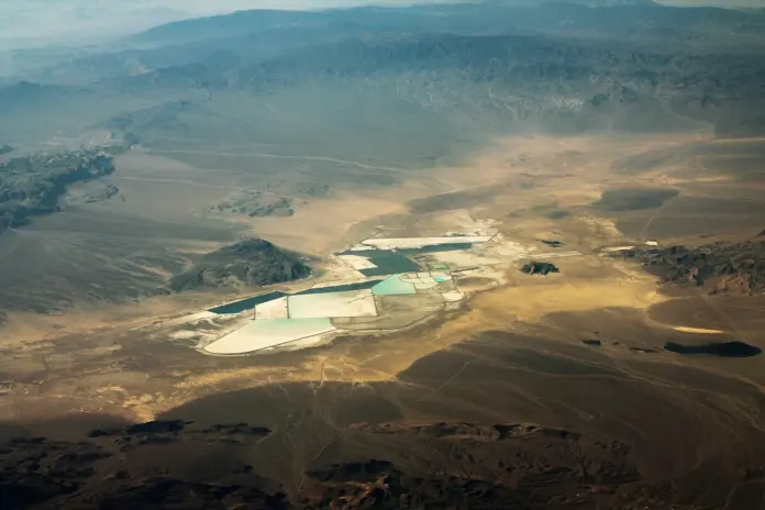 The United States government does not own five per cent of Lithium Americas Corp. (NYSE: LAC). It owns something more interesting, and almost every write-up of the trade has blurred the distinction by filing this under the general heading of "the government took a stake." When the Department of Energy restructured its Thacker Pass loan, it did not buy shares and it did not write an equity cheque. On 30 January 2026 it took delivery of <em>warrants</em>: an option to acquire 18,268,687 LAC common shares at an exercise price of one cent, equal to 5% of shares outstanding on the issuance date, per the company's <a href="https://www.sec.gov/Archives/edgar/data/1966983/000119312526347826/lac-20260630.htm">Form 10-Q filed 13 August 2026</a>. With LAC closing at $3.43 on 13 August 2026 (<a href="https://stockanalysis.com/stocks/lac/">StockAnalysis.com</a>), Washington holds a claim on the upside of a pre-revenue mining developer for which it has agreed to pay, in total, roughly $183,000.
Here is the part nobody is writing, and it is the reason this page exists. There are <strong>two</strong> warrants, not one. Alongside the parent-company warrant, the joint venture that owns Thacker Pass issued the DOE a second warrant over 8,656,509,695 non-voting JV units — a 5% economic interest in the project itself, struck at $0.0001 per unit. The 10-Q puts the combined fair value of both instruments at inception at <strong>$394.1 million</strong>, booked as a deferred financing cost. Of that, only $88.8 million was the LAC-level warrant. The JV-level warrant was worth roughly $305.3 million — about 3.4 times more. And under a Put, Call and Exchange Agreement signed at the same time, the DOE may require General Motors to buy the JV warrant, or, failing agreement on price, <strong>exchange it for Lithium Americas common shares</strong>. The federal claim on the equity is therefore not capped at 5% of the share count. It has a second, larger tranche sitting one contract away from the same register.
That single structural fact reframes both sides of this trade. It is why the bull case here is genuinely asymmetric, and it is why the dilution risk is larger than the headline number implies. This analysis sets a bull case of <strong>$7.20</strong>, which is <strong>109.9% above</strong> the $3.43 spot, and a bear case of <strong>$2.20</strong>, which is <strong>35.9% below</strong> it. Both are stated against the same verified close, and neither is a recommendation.
Key facts, verified
<strong>Spot $3.43</strong>, +5.21% (+$0.17) on 13 August 2026; prior close $3.26; day range $3.31–$3.49 on 12.15m shares — <em>StockAnalysis.com, 14 Aug 2026</em>
<strong>52-week range $2.66–$10.52.</strong> Spot sits <strong>67.4% below</strong> the 52-week high, yet is <strong>up 16.3%</strong> over one year (from $2.95) — <em>StockAnalysis.com</em>
<strong>363,042,943 shares outstanding</strong> as of 12 August 2026 → market capitalisation of roughly <strong>$1.25 billion</strong> at spot — <em>LAC 10-Q, 13 Aug 2026</em>
<strong>$1.279 billion</strong> in cash and restricted cash at 30 June 2026 ($822.8m cash, $456.4m restricted), of which <strong>$530.3 million sits at the JV</strong> and is unavailable for general corporate purposes — <em>LAC 10-Q</em>
<strong>DOE loan: $2.26 billion</strong> at signing ($1.97bn principal plus up to $289.6m capitalised interest), later trimmed to $2.23bn total. <strong>$1.209 billion drawn</strong> across three advances — <em>LAC Q2 2026 release, 13 Aug 2026</em>
<strong>GM owns 38%</strong> of the Thacker Pass JV; Lithium Americas owns 62% and operates it — <em>LAC 10-Q</em>
<strong>Mechanical completion targeted late 2027</strong>, production ramp during 2028. Phase 1 nameplate <strong>40,000 t/y</strong> of battery-quality lithium carbonate against a 44.5 Mt LCE measured-and-indicated resource — <em>LAC 10-Q; <a href="https://lithiumamericas.com/thacker-pass/overview/">Lithium Americas</a></em>
What the price chart is actually saying
Spot of $3.43 is a 67.4% drawdown from the $10.52 52-week high and only 29% above the $2.66 low. But the twelve-month change is <em>positive</em> 16.3%. That combination — a violent round trip that ends slightly up — is the signature of a stock that repriced on a financing event and then gave it all back. The October 2025 loan restructuring and the equity kicker that came with it drove the melt-up; the equity issuance that followed drove the unwind.
Lithium Americas (NYSE: LAC) price history with bull and bear levels marked against spot. Price data: StockAnalysis.com, close of 13 August 2026.
You can watch that unwind in the company's own selling. Under its at-the-market programmes, LAC sold 32.5 million shares at an average of <strong>$5.92</strong> in Q1 2026, then 13.0 million at <strong>$5.36</strong> in Q2, then 1.1 million at <strong>$3.87</strong> after quarter-end. The company's own realised issuance price fell 34.6% in two quarters. That is not a chart pattern; it is a funding cost, and it compounds.
The sell-side is not enthusiastic. The consensus one-year target across 12 analysts polled by S&P Global is <strong>$5.66</strong> — 65.0% above spot — on a <strong>Hold</strong> rating, with a low of $3.30 (3.8% <em>below</em> spot) and a high of $10.00 (191.5% above), last updated 2 July 2026 (<a href="https://stockanalysis.com/stocks/lac/forecast/">StockAnalysis.com</a>). Note where our levels sit relative to that: the $7.20 bull case is above consensus but well inside the street high, and below the 52-week high of $10.52, which makes it a recovery case rather than a new-high case. The $2.20 bear case is below the street's lowest published target and below the 52-week low — it is explicitly a scenario, not an extrapolation.
The warrant, decoded — and why it is the whole story
A warrant is not ownership. It is a right to acquire ownership, and on a conventional at-the-money warrant the distinction matters enormously: the holder only converts if the stock rises, so existing holders are diluted only in the good scenario. That is the framing most coverage has reached for, and on LAC it is wrong in an important way.
The DOE's LAC warrant is struck at <strong>$0.01</strong>. At a penny, it is not really an option on the outcome; it is equity wearing an option's clothing. Exercisable for ten years from issuance, it will be converted in any state of the world in which Lithium Americas is still a going concern. The accountants have already noticed. The 10-Q states that basic earnings per share is computed on a share count "which includes shares issuable for little to no consideration upon the exercise of the LAC Warrant" — the dilution is already inside the reported per-share numbers. That is why Q2's weighted-average basic share count of 371.8 million exceeds the 363.0 million shares actually issued and outstanding in August.
So what did the government really pay for it? Nothing in cash — but the company paid, and the filing quantifies it. The $394.1 million combined fair value of the two warrants was recognised as deferred financing cost against a $1.97 billion loan principal. That is an equity kicker equal to <strong>20% of the principal</strong>. Its effect shows up in the interest line: the 10-Q reports an effective interest rate of approximately <strong>6.36%</strong> on the first advance against a contractual coupon of <strong>4.38%</strong> — the warrants add roughly 200 basis points to the true cost of what is nominally cheap federal money. A 4.38% construction loan for a lithium developer is exceptional. A 6.36% one is merely good.
This is the honest synthesis, and it cuts both ways. Bulls get a project financed at a rate no private lender would offer a pre-revenue miner. Bears get a capital structure in which the largest creditor is also a shareholder-in-waiting with a second, bigger claim held at the project level and a contractual path to convert it into parent-company stock. It is worth being precise about how unusual this is, because "the government took a stake" has become a catch-all for arrangements whose terms differ enormously. Our <a href="https://financefeeds.com/intel-stock-prediction-148-bull-case-62-bear-case/">Intel bull and bear analysis</a> records 158.74 million shares placed in escrow — roughly 10% of the company — under an agreement dated 22 August 2025. That is a different instrument, a different size and a different trigger, attached to a business with tens of billions of dollars of revenue. Beyond the headline percentages, the terms of these arrangements are frequently not documented in a form that permits clean comparison, which is exactly why the specific mechanics of the LAC warrants — filed, dated and fair-valued in a 10-Q — deserve more attention than the label attached to them.
The build: what $1.8 billion has actually bought
Thacker Pass is real and it is being built. As of 30 June 2026, $1.8 billion of construction capital and project costs had been capitalised, of which $1.6 billion counts against the $2.93 billion capex estimate in the December 2024 NI 43-101 technical report. Detailed engineering surpassed 95% and procurement exceeded 80%. Over 1,600 people were on site, with more than 2,000 expected by year-end, and 1,500-plus housed at the company's Winnemucca workforce hub. Safety metrics are strong: 3.42 million work-hours with no serious injury or lost-time incident.
Jonathan Evans, President and Chief Executive Officer of Lithium Americas, said in the <a href="https://www.sec.gov/Archives/edgar/data/1966983/000119312526347834/lac-ex99_1.htm">Q2 2026 results release</a> on 13 August 2026: "We are safely accelerating construction toward peak activity and peak labor later this year, with mechanical completion still targeted for late 2027. Thacker Pass is reaching new vertical heights as structural steel and concrete work at the processing plant advances through second-floor installations. Across the site, we are transitioning into piping and electrical trades and are receiving more than 60 truckloads of equipment and materials each day. All off-site power modifications are complete, and we remain on track for energization in Q4 2026."
One detail in that supply chain deserves attention from anyone who has been following the macro tape. More than 85% of Thacker Pass's structural steel is sourced from the United Arab Emirates, and the 10-Q states that the company and Bechtel have worked with the supplier to minimise the impact of the Middle East conflict — including the closure of the Strait of Hormuz — on fabrication and shipping. A Nevada lithium mine's schedule now has a Gulf shipping-lane dependency, a theme running through our <a href="https://financefeeds.com/global-fx-market-summary-gold-oil-and-fed-shifts-drive-markets-hormuz-delays-and-yen-slump-lead-august-10-2026/">10 August FX and commodities wrap</a>.
The commodity backdrop, meanwhile, is not what most LAC commentary assumes. The lazy line is that lithium has collapsed and stayed collapsed. Lithium carbonate traded at <strong>151,500 CNY/t on 14 August 2026, up 84.77% year-on-year</strong> though down 1.62% over the past month, per <a href="https://tradingeconomics.com/commodity/lithium">Trading Economics</a>. The price remains far below its late-2022 peak, but it has been rising hard for a year while LAC shares fell 67% from their own high. That divergence is the bull case in one line: the equity de-rated on financing, not on the commodity.
The bull case: $7.20, or 109.9% above spot
Start with the floor. At $3.43 and 363.0 million shares, the market capitalisation is roughly <strong>$1.25 billion</strong> against $1.279 billion of cash and restricted cash. The stock trades at approximately its gross cash balance. That is not a net-cash story — the DOE loan carried a $1.23 billion balance at 30 June and Orion's convertible notes add $116.0 million, so net debt is roughly flat, not negative — but it does mean the market is currently ascribing close to nothing for 44.5 million tonnes of LCE resource, an 85-year mine life, a 95%-engineered plant, and a permitted site. Readers who have followed how a cash balance can anchor a speculative equity will recognise the mechanic from our <a href="https://financefeeds.com/qubt-stock-price-prediction-18-bull-case-vs-6-25-cash-floor/">QUBT cash-floor analysis</a>.
The bull path to $7.20 needs three things, in order. First, mechanical completion holds at late 2027 — no slip announced through 2027 guidance. Second, the remaining DOE capacity funds the build: with $1.209 billion drawn of $1.97 billion principal, roughly $761 million remains available, which against a 2026 capex guide of $1.3–1.6 billion and $1.33 billion of remaining spend on the $2.93 billion estimate means the loan plus existing cash can plausibly carry the project without a large equity raise. Third, lithium carbonate holds above roughly current levels into first production, so that a 40,000 t/y Phase 1 has an economic market to sell into.
Get all three and the re-rate mechanism is straightforward: as a developer moves from "will it be built" to "it is commissioning", the market stops discounting for construction risk and starts discounting cash flows. At $7.20, LAC would carry a market capitalisation of roughly $2.6 billion — still 31.6% below its own 52-week high, and a modest figure against $2.93 billion of capex on a single phase of a five-phase, 160,000 t/y resource. That is what makes this a recovery case rather than a fantasy. The comparable dynamic in other pre-revenue energy developers is visible in our <a href="https://financefeeds.com/nuscale-smr-stock-prediction-18-bull-4-50-bear/">NuScale SMR bull and bear analysis</a> and in our coverage of <a href="https://financefeeds.com/oklo-earnings-bullish-87-bearish-14/">Oklo's first revenue quarter</a>, where the first dollar of commercial output mattered far more than its size.
The policy layer is the accelerant. Evans framed it directly in the same release: "Lithium is central to America's economic and national security, sustaining resilient military operations, powering essential civilian infrastructure, and underpinning the technologies driving modern economic growth, from consumer electronics to grid-scale energy storage. Securing a reliable domestic supply is essential to meeting rising electricity demand, strengthening our energy independence and ensuring the United States wins the global technology race." A government that holds penny warrants over 5% of a company and 5% of its flagship project has, whatever one thinks of the policy, given itself a direct financial incentive to see that project finished.
The bear case: $2.20, or 35.9% below spot
The bear case is not a lithium-price case. It is a share-count case, and it acquired a name on 5 August 2026.
On that date Lithium Americas signed a securities purchase agreement with YA II PN, Ltd., an affiliate of Yorkville Advisors, for up to <strong>$175 million</strong> of subordinated convertible debentures, with $150 million agreed at the initial closing. Read the conversion terms carefully, because they are the crux. The debentures convert at the holder's option at the lower of (i) a fixed price — the higher of 140% of the prior day's NYSE close and $3.79 — or (ii) <strong>95% of the lowest daily VWAP over the five trading days immediately preceding conversion</strong>, subject to a floor at 50% of the issuance-date close, reducible in certain circumstances to no less than 20%. Interest starts at 5% but steps to 7.50% and then 15% if specified events occur, including the stock trading below the floor price for a specified period or the exchange cap being substantially exhausted.
That is a floating-conversion structure, and its arithmetic is unsentimental: the lower the share price goes, the more shares each dollar of principal converts into. As an illustration rather than a forecast, $150 million converting near a 95%-of-VWAP price around today's $3.43 implies roughly 46 million new shares — about 12.7% of the current count. Convert at $2.50 and it is closer to 63 million shares. The instrument mechanically issues more paper precisely when the equity is weakest.
Stack that on the rest of the overhang and the bear path becomes legible. The March 2026 ATM programme has sold 14.1 million shares for about $72.7 million net of a $250 million authorisation, leaving substantial capacity — and management has demonstrated it will use it at $3.87. Orion's $116.0 million of notes convert at $3.78. The DOE's 18.3 million penny-warrant shares are already in the basic count. And the JV warrant, fair-valued at roughly $305.3 million at inception, sits behind an agreement that can push it onto the common register if GM and the DOE cannot agree a price.
Add an execution stumble to that structure and $2.20 arrives without needing a thesis change. A schedule slip past late 2027 does two things at once: it extends the period during which a company with zero revenue must fund overhead and cost inflation, and it pushes out the moment when the market is willing to pay for cash flows rather than discount for risk. The 10-Q is explicit that the company "will not generate revenues from operations until after Thacker Pass begins production" and expects to keep operating at a loss for the foreseeable future. Tariff exposure on equipment sourced from Canada, China, India, the UAE, Turkey and the EU is disclosed as a live variable, mitigated only by the roughly 75% of the cost base that is labour and services.
At $2.20 the market capitalisation would be about $800 million pre-dilution, or below its own restricted-cash balance — a level that implies the market has stopped believing Phase 1 gets commissioned on the current plan. It is 17.3% below the 52-week low and below the lowest published street target of $3.30, which is precisely why it belongs in a bear column and not a base case. Investors who want the same commodity exposure without single-asset execution risk have historically reached for diversified producers of the kind covered in our <a href="https://financefeeds.com/energy-stocks-ccj-99-ceg-279-eqt-54-vst-147/">energy stocks review</a> or the London-listed mining route explored in our piece on <a href="https://financefeeds.com/baron-securities-launches-to-bring-canadian-mining-companies-to-londons-capital-markets/">Baron Securities and Canadian mining listings</a>.
What would change the call
Three signposts do most of the work between now and first production.
<strong>Energization in Q4 2026.</strong> Evans has committed to it publicly and it is the nearest binary. Off-site power modifications are complete; if energization lands on schedule, the late-2027 mechanical completion date gains real credibility. If it slips, every subsequent milestone inherits the delay and the bear case moves from possible to probable.
<strong>How the Yorkville debentures actually convert.</strong> Watch the share count in the Q3 and Q4 10-Qs, not the press releases. If conversions land near the $3.79 fixed floor rather than the floating VWAP price, the dilution is manageable. If the variable leg dominates, the structure is doing what floating-conversion paper does.
<strong>The remaining $761 million of DOE capacity.</strong> Each advance is conditional. Three have landed — $435 million in October 2025, $432 million in February 2026, $342 million in June 2026. A missed or delayed draw would be the single most damaging headline available to this equity, because it would simultaneously signal a covenant or milestone problem and force the company toward the dilutive instruments it already has in place.
Our prediction, with the causal chain stated: the warrant structure means Washington's incentives are now aligned with completion rather than repayment alone, which materially lowers the probability of the loan being pulled — but it does nothing to lower the probability of equity dilution, because the DOE's claim is on shares, not cash. Expect the next twelve months to be decided by the share count rather than by the lithium price. That is an unusual thing to say about a mining stock, and it is exactly why LAC does not trade like one.
Frequently asked questions
<strong>Does the US government own 5% of Lithium Americas?</strong>Not yet. It holds a warrant to purchase 18,268,687 common shares at $0.01 each, equal to 5% of shares outstanding on the 30 January 2026 issuance date, exercisable for ten years. It also holds a separate warrant over a 5% economic interest in the Thacker Pass joint venture. Because the LAC warrant is struck at a penny, the company already includes those shares in its basic earnings-per-share calculation.
<strong>What is the Lithium Americas bull case price target?</strong>This analysis sets a bull case of $7.20, which is 109.9% above the verified spot price of $3.43 as of the 13 August 2026 close. It sits above the $5.66 analyst consensus but below both the $10.00 street high and the $10.52 52-week high, making it a recovery target rather than a new-high target.
<strong>What is the bear case for LAC stock?</strong>A bear case of $2.20, which is 35.9% below the $3.43 spot and 17.3% below the 52-week low of $2.66. It assumes heavy conversion of the floating-price Yorkville debentures alongside continued at-the-market issuance and a slip in the late-2027 mechanical completion target.
<strong>When will Thacker Pass start producing lithium?</strong>Lithium Americas targets mechanical completion of Phase 1 in late 2027, with production ramp-up during 2028. Phase 1 nameplate capacity is 40,000 tonnes per year of battery-quality lithium carbonate, against a measured-and-indicated resource of 44.5 million tonnes LCE and a stated 85-year mine life.
<strong>Does Lithium Americas have enough cash to finish the project?</strong>The company held $1.279 billion in cash and restricted cash at 30 June 2026 and says it has sufficient liquidity for at least the next 12 months, counting undrawn DOE loan capacity. Roughly $761 million of the $1.97 billion loan principal remains undrawn. Beyond 12 months, further financing is contemplated.
<strong>How much of Thacker Pass does GM own?</strong>General Motors holds a 38% interest in the joint venture; Lithium Americas holds 62% and operates the project. GM also has an offtake agreement for Phase 1 lithium and a call right over the DOE's JV warrant following substantial completion.
<em>Analysis, not investment advice. Lithium Americas is a pre-revenue development-stage company with no operating income, a single flagship asset, an explicit going-concern dependency on further financing, and multiple dilutive instruments outstanding. Price targets in this article are scenario analysis derived from publicly filed data, not forecasts, and speculative developers can lose the majority of their value. All prices are as of the close on 13 August 2026 and will change. Do your own research and consider your risk tolerance before acting.</em>