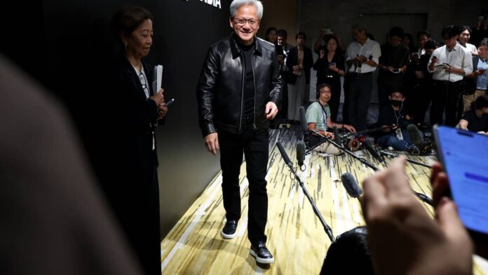 Chief executives get two microphones. One is bolted to an earnings call, where every number carries legal weight and a team of lawyers reads it first.
The other is a hallway, a stage, or a scrum of reporters, where the same person can say almost anything.
Nvidia (NVDA) has used both for three years, and the pattern has held. The company guides carefully in writing. Then its founder talks about the future in round numbers that make the written guidance look timid.
That split has mostly worked in shareholders’ favor. Nvidia has spent three years beating its own revenue guidance, so the expansive version kept turning out to be the accurate one. Investors learned to treat the hallway version as a preview rather than a promise.
On Thursday, Sept. 17, the two versions stopped agreeing.
Speaking to reporters at an artificial intelligence (AI) gathering convened by King Charles III in Scotland, Jensen Huang said Nvidia expects to sell twice as many chips over the coming year, according to <a href="https://www.bloomberg.com/news/articles/2026-09-17/nvidia-s-huang-expects-to-sell-twice-as-many-chips-next-year">Bloomberg</a>.
Nvidia’s own paperwork calls for something smaller.
How Nvidia turns chip supply into revenue growth
Nvidia sells far more than the data center graphics processing units (GPUs) that dominate the headlines. It also sells central processors, networking switches, optical chips, laptop silicon, and the processor inside Nintendo’s Switch 2.
That mix matters, because a chip is not a fixed unit of revenue. A Blackwell rack system and a laptop GPU each count as one chip sold. They do not count as the same dollars.
<strong>More Nvidia</strong>:
<a href="https://www.thestreet.com/technology/coreweave-ai-infrastructure-milestone"><strong>Nvidia cloud partner crosses major compute threshold</strong></a>
<a href="https://www.thestreet.com/investing/stocks/jim-cramer-nvidia-stock-verdict"><strong>Jim Cramer drops 5-word verdict on Nvidia stock</strong></a>
<a href="https://www.thestreet.com/markets/nvidia-ceo-jensen-huang-doubles-down-on-his-big-2030-market-bet"><strong>Nvidia CEO Jensen Huang doubles down on his big 2030 market bet</strong></a>
The distinction rarely came up while the data center business was swallowing everything else. Revenue for the quarter ended July 26 was $96.2 billion, up 106% from a year earlier, with data center sales of $89.0 billion, according to <a href="https://nvidianews.nvidia.com/news/nvidia-announces-financial-results-for-second-quarter-fiscal-2027">Nvidia’s earnings statement</a>.
Gross margin that quarter was 75.0%, the same statement confirmed, and Huang’s summary of the business was three words: <strong>“Compute is revenue.”</strong>
That is the machine. Chips go out, margin comes back, and the market pays roughly 30 times earnings for the privilege of watching it run.
Huang says Nvidia chip units will double next year, but NVDA guidance implies 70% revenue growth.<a href="https://www.gettyimages.com/detail/2285783667">Bloomberg / Getty Images</a>
What Huang’s doubled chip forecast leaves out
Nvidia has guided to about 70% revenue growth for the fiscal year ending in January 2028, which works out to roughly $673 billion, according to <a href="https://www.cnbc.com/2026/09/17/nvidia-huang-ai-chip-guidance.html">CNBC</a>. Huang’s comment in Scotland points to unit volumes doubling, which is 100%.
Those are two different measures, and I ran them against each other before writing a word of this piece. If units double while revenue grows 70%, average revenue per chip falls by roughly 15%.
That is arithmetic, not opinion, and three explanations fit it.
Nvidia may be sandbagging its written guidance again, which is the friendliest reading.
The product mix may be tilting toward cheaper parts as AI spreads into laptops, cars, and robots.
Huang may have been describing a supply scenario his company has not committed to on paper.
He gave the demand reason himself, telling reporters that in almost every country where Nvidia operates, “people want to invest in AI,” <a href="https://www.cnbc.com/2026/09/17/nvidia-huang-ai-chip-guidance.html">CNBC reported</a>.
Two Nvidia forecasts, side by side
Chip units sold will roughly double over the coming year, Huang told reporters in Scotland, according to <a href="https://www.bloomberg.com/news/articles/2026-09-17/nvidia-s-huang-expects-to-sell-twice-as-many-chips-next-year">Bloomberg</a>.
Revenue is guided to grow about 70% in the fiscal year ending January 2028, or roughly $673 billion, <a href="https://www.cnbc.com/2026/09/17/nvidia-huang-ai-chip-guidance.html">CNBC</a> noted.
Second-quarter revenue was $96.2 billion at a 75.0% gross margin, according to <a href="https://nvidianews.nvidia.com/news/nvidia-announces-financial-results-for-second-quarter-fiscal-2027">Nvidia’s earnings statement</a>.
Third-quarter revenue is guided to $108 billion, plus or minus 2%, the same statement indicated.
The margin math behind doubling Nvidia shipments
Nvidia has already told investors where the pressure lands. Gross margin will decline and bottom out in the fourth quarter of fiscal 2027 at 71% to 72%, partly because of memory prices, according to <a href="https://www.cnbc.com/2026/08/26/nvidia-nvda-earnings-report-q2-2027-live-updates.html">CNBC’s earnings coverage</a>.
Finance chief Colette Kress framed the memory shortage as a problem the AI buildout is creating for itself, CNBC noted.
What struck me in my analysis of that guidance is the sequencing. The margin trough arrives before the unit doubling does.
<strong><a href="https://www.thestreet.com/markets/jensen-huang-just-sent-wall-street-a-message-about-agi">Related: Jensen Huang just sent Wall Street a message about AGI</a></strong>
Shipping twice as many chips at 71% is a different business from shipping half as many at 75%. It is still an extraordinary business. It is a less profitable one per unit, and that is the part a doubling headline hides.
Huang has doubled down before. He <a href="https://www.thestreet.com/markets/nvidia-ceo-jensen-huang-doubles-down-on-his-big-2030-market-bet">repeated a $3 trillion to $4 trillion global AI infrastructure forecast for 2030</a> at a Wall Street technology conference on Sept. 10.
For a stock carrying a market value above $5 trillion, revenue per chip is the line that decides whether next year repeats this one.
Why AI oversight is the wild card for Nvidia investors
The Scotland event was not a sales conference. King Charles III used it to press the industry, telling executives from Nvidia, OpenAI, Google DeepMind, and Anthropic that “we need sufficient means of control before it is all too late,” according to <a href="https://fortune.com/2026/09/17/king-charles-ai-existential-dangers-control/">Fortune</a>.
Huang’s answer was that safety belongs to individual companies rather than a coordinated pause. When a product is not safe enough, “we should hold it back and keep engineering,” he said, <a href="https://www.scrippsnews.com/science-and-tech/artificial-intelligence/the-king-and-ai-uk-monarch-charles-meets-artificial-intelligence-leaders-as-safety-concerns-swirl">Scripps News reported</a>.
That position is consistent, and it is also commercially convenient. Nvidia’s customers are the labs being asked to slow down, and every month of delay in a training run is a month of deferred orders.
No regulator was blocked in Scotland, because no regulator with authority over frontier models exists yet. What happened is that the most powerful supplier in the chain argued against creating one, in front of a head of state who had just asked for it.
If that argument loses anywhere, whether in Brussels, Washington, or London, the unit ramp acquires a governor it does not currently have.
What the Nvidia chip forecast means for your money
Nvidia carries the heaviest weight in the S&P 500. If you hold an index fund, a target-date fund, or whatever your 401(k) put you in by default, you own this forecast whether or not you follow chip pricing.
The temptation is to read “twice as many chips” as twice as good. Twice as many chips is a different claim from twice the revenue, and Nvidia’s own filings say so.
The number worth marking on your calendar is the gross margin line in November’s third-quarter report. If it holds near 74%, Huang’s version wins, and the written guidance was conservative.
If it slides toward the 71% floor while the unit talk keeps climbing, the market will be paying for volume it cannot bank.
Huang has been right more often than he has been wrong, and betting against him has been an expensive hobby.
The thing to watch this time is not whether he is right about the chips. It is whether each one is still worth what it was.
<strong><a href="https://www.thestreet.com/investing/stocks/jensen-huang-just-answered-michael-burrys-nvidia-bear-case-coreweave">Related: Jensen Huang just answered Michael Burry’s Nvidia bear case</a></strong>