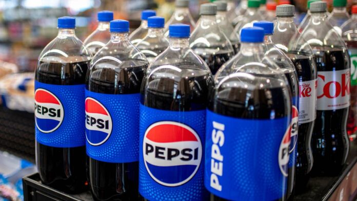 A warehouse shift in Tulsa will result in 184 job cuts, even as production lines beside it continue to operate.TheStreet recently reported that <a href="https://www.thestreet.com/employment/coca-cola-soda-giant-closes-plant-cuts-175-jobs">Coca-Cola</a> is closing a Massachusetts bottling plant, while Mars-owned <a href="https://www.thestreet.com/employment/mars-popular-snack-brand-close-plant-cuts-345-jobs">Nature’s Bakery</a> is transferring production from a Missouri facility to other locations.The circumstances differ, but both showed how companies are redrawing their manufacturing and distribution networks while their products remain widely available to shoppers.Now a similar shift is affecting PepsiCo workers in Tulsa, Oklahoma.<strong>PepsiCo cuts 184 Tulsa warehouse jobs</strong>PepsiCo Beverages will discontinue warehouse operations at its facility at 510 W. Skelly Drive, Tulsa, on Nov. 15, according to a <a href="https://www.employoklahoma.gov/Participants/s/warnnotices">Worker Adjustment and Retraining Notification (WARN) notice</a> reviewed by TheStreet.The closure will impact 184 jobs and is expected to be permanent, affecting nearly all warehouse employees at the facility, on or Nov. 15, 2026.The rest of the plant will remain open, and beverage production will continue.<strong>More Layoffs:</strong><a href="https://www.thestreet.com/employment/meta-layoffs-discrimination-retaliation-lawsuit"><strong>Meta layoffs take disturbing turn in new lawsuit</strong></a><a href="https://www.thestreet.com/employment/mars-popular-snack-brand-close-plant-cuts-345-jobs"><strong>Major snack brand closes plant, cuts 345 jobs</strong></a><a href="https://www.thestreet.com/employment/jpmorgan-chase-pushes-fraud-division-layoffs-despite-rising-revenues"><strong>JPMorgan Chase pushes fraud division layoffs, despite rising revenues</strong></a>The largest groups affected include 63 warehouse workers and 57 forklift operators.The <a href="https://www.thestreet.com/employment/layoffs">layoffs</a> also include 16 checkers, 13 inventory-control specialists, 12 lead workers, supervisors, coordinators, and other supply-chain employees.“PepsiCo Beverages U.S. is shifting warehouse operations to a new facility in the Tulsa area to best support our customers and consumers; production will continue to operate at the current facility,” PepsiCo Beverages US said in a statement to TheStreet.“We are committed to treating impacted employees with the utmost care, including assistance applying to work with the new logistics provider, pay and benefits continuation based on years of service, transition assistance, and career support,” the statement added.The WARN notice also said PepsiCo is working to place affected employees in other jobs at the Tulsa plant or nearby facilities.However, PepsiCo did not identify the new warehouse location or the logistics provider that will operate it. The company also did not disclose how many workers could secure other roles.
PepsiCo's stock is down 4% year to date.<a href="https://www.gettyimages.com/detail/2284663194">Bloomberg / Getty Images</a>
<strong>PepsiCo warehouse cuts extend beyond Tulsa</strong>The Tulsa restructuring follows other recent changes across PepsiCo’s U.S. warehouse and distribution network.Frito-Lay closed its <a href="https://edd.ca.gov/en/Jobs_and_Training/Layoff_Services_WARN">Rancho Cucamonga, California</a>, warehouse in June, eliminating 248 logistics and distribution jobs.Manufacturing at the location had already ended in 2025, but warehouse and distribution operations continued until this year. PepsiCo said the remaining work would be transferred to a newer local distribution center.An off-site Frito-Lay warehouse in Orlando also closed in May, affecting 46 workers.That followed the November 2025 shutdown of a nearby manufacturing plant and warehouse that <a href="https://reactwarn.floridajobs.org/WarnList/Records?year=2025">eliminated 454 jobs</a>.The circumstances at each location differ.Still, the moves show PepsiCo consolidating or relocating work across parts of its U.S. network rather than keeping every existing warehouse and production site operating as before.The Tulsa decision is narrower because the production plant itself is not closing. But for workers whose jobs depend on storing, checking, and moving products, the impact is losing their jobs.<strong>PepsiCo tests a new distribution model</strong>PepsiCo executives recently explained why the company is taking a closer look at its warehouses, transportation systems, and delivery routes.During its July 9 second-quarter 2026 <a href="https://www.thestreet.com/dictionary/e/earnings-call">earnings call</a>, CEO Ramon Laguarta said PepsiCo is trying to combine more of the scale of its North American food and beverage businesses.Historically, the two businesses have operated through largely separate inventory, warehouse, and delivery systems.PepsiCo is now testing “mixing centers” in the Texoma region that bring food and beverage inventory together at the same location. The company is also testing combined deliveries and vehicle fleets.Laguarta said the model gives PepsiCo more flexibility when serving customers while lowering its costs.“We’re seeing mixing centers being a big idea for us, and that is scaling,” said Laguarta in the <a href="https://investors.pepsico.com/docs/pepsico-5v9wci20/media/Files/investors/q2-2026-pep-transcript.pdf">Q2 earnings call</a>.“These are combined mixing centers where we put the inventory from the two categories," he noted. "That gives us a lot of flexibility to service our customers and lowers our cost. Now, we’re testing incremental ideas like combined delivery, combined fleet.”PepsiCo did not say that the Tulsa move is directly connected to the Texoma tests.However, shifting warehouse operations to a new facility and logistics provider aligns with the company’s broader effort to rethink how products move through its U.S. <a href="https://www.thestreet.com/dictionary/s/supply-chain">supply chain</a>.The company has also been expanding automation and digital tools as part of a wider productivity push.<strong>Beverage demand remains pressured</strong>In terms of financial position, PepsiCo reported <a href="https://investors.pepsico.com/docs/pepsico-5v9wci20/media/Files/investors/q2-2026-earnings-release.pdf">second-quarter</a> net revenue of $24.18 billion, up 6.4% from a year earlier. Organic revenue increased 2.4%.However, the company’s North American beverage results were more mixed, and it missed earnings expectations.PepsiCo Beverages North America revenue rose 7%, but acquisitions accounted for six percentage points of that growth.Organic revenue increased 1%, while beverage volume declined 4%.<a href="https://www.thestreet.com/dictionary/w/wall-street">Wall Street</a> had already warned that PepsiCo’s North American recovery could take longer than expected.In a June 25 note, Bank of America lowered its 2026 earnings estimate for PepsiCo to $8.61 from $8.65 and cut its price target to $164 from $173, citing softer-than-expected performance at PepsiCo Foods North America. The bank also said core Pepsi <a href="https://www.thestreet.com/dictionary/r/retail-sales">retail sales</a> were down 6.8% year to date, while Mountain Dew sales had declined 2.3%, highlighting pressure across some of the company’s biggest U.S. brands.PepsiCo executives said the North American business performed more weakly than expected during the quarter, as higher gas prices pressured convenience-store traffic and impulse purchases.The company said it achieved record productivity during the first half of the year and plans to pursue additional savings during the second half.PepsiCo maintained its 2026 forecast for organic revenue growth of 2% to 4% and core constant-currency earnings growth of 4% to 6%.The food and beverage maker is growing overall, but demand remains softer in parts of its North American business. This comes as the company tries to lower costs by combining operations and changing how products are stored and delivered. It's also simultaneously growing its business internationally.<strong><a href="https://www.thestreet.com/travel/iconic-hotel-that-serves-as-entry-to-national-park-files-for-chapter-11-bankruptcy">Related: 105-year-old historic hotel by national park files for Chapter 11 bankruptcy</a></strong>