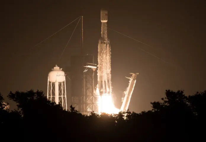 SpaceX stock is not expensive because the market has lost its mind about rockets. It is expensive because the market has already agreed to pay for an artificial-intelligence business that does not yet appear in the accounts — and the two contracts underpinning that business can each be cancelled on 90 days' notice. That is the whole SPCX debate in one sentence, and it is why our 12-month range is a <strong>$215 bull case against a $90 bear case</strong> from a last close of <strong>$136.97</strong> on 21 August 2026. SpaceX booked <strong>$7.81bn of Q2 revenue, up 92% year on year</strong>, and spent <strong>$18.37bn on capital expenditure in the same three months</strong> — 235% of revenue. Free cash flow for the first half was <strong>negative $25.0bn</strong>. Those are the numbers that decide which case wins, and neither the bulls nor the bears have to invent anything to make their argument.
Here is the part almost nobody has run the arithmetic on. Chief Financial Officer Bret Johnsen guided investors to <strong>$100bn of annualised revenue run-rate by December 2026</strong>. Working forward from the Q2 actual and adding only the incremental contracts SpaceX has actually disclosed — the Google agreement that begins in October and the $6.7bn of third-quarter cloud contracts management referenced on the call — we can build roughly <strong>$56bn</strong> of December ARR. That leaves a gap of about <strong>$44bn</strong>, and it implies December revenue running at <strong>3.2 times</strong> the Q2 monthly rate. Be fair to the company and assume the Anthropic contract steps up from its reduced ramp fee to its full $1.25bn per month, and the build reaches roughly $64.6bn — the gap narrows to about $35bn, but it does not close. SpaceX has simply not disclosed contracts accounting for it. Part may be Cursor, whose revenue the company has never broken out. That is the single most important unanswered question in the stock, and it is answered in December, not before.
SPCX closing price since its June 2026 Nasdaq debut. Source: stockanalysis.com daily closes; chart by FinanceFeeds.
Key facts
<strong>Last close $136.97</strong>, 1.5% above the $135.00 IPO price and 39.3% below the $225.64 intraday peak of 16 June — <em>stockanalysis.com, 21 August 2026</em>
<strong>Q2 revenue $7,814m, up 92%</strong> from $4.1bn; net loss <strong>$(541)m</strong>; adjusted EBITDA $3,538m — <em><a href="https://www.sec.gov/Archives/edgar/data/1181412/000162828026052515/earningsreleaseq22608042.htm">SpaceX Q2 2026 earnings release (8-K EX-99.1)</a>, 4 August 2026</em>
<strong>Q2 capital expenditure $18,369m</strong>, of which $15,828m was AI infrastructure — equal to <strong>235% of quarterly revenue</strong> — <em>same release</em>
<strong>First-half free cash flow −$25.0bn</strong> ($3,466m operating cash flow less $28,476m capex) — <em>FinanceFeeds calculation from the Q2 release</em>
<strong>$100.0bn cash and securities against $39.4bn of debt</strong>, of which <strong>$13.3bn is owed to Valor</strong>, an entity related to a company director, carrying $327m of interest in the quarter alone — <em><a href="https://www.sec.gov/Archives/edgar/data/1181412/000162828026052535/spcx-20260630.htm">Q2 2026 Form 10-Q, Note 17</a></em>
<strong>Two customers were 37.8% of Q2 revenue</strong> — Customer A at 18.3% and Customer B at 19.5% — <em>10-Q, Note 3</em>
<strong>Enterprise value roughly $1.80trn on $23.0bn of trailing revenue: 78x sales</strong> — <em>FinanceFeeds calculation from SEC filings, corroborated by stockanalysis.com</em>
What the June IPO actually priced, and what has happened since
SpaceX listed on Nasdaq in June 2026 at $135 a share. The stock closed its first session at $192.50, peaked at $225.64 intraday on 16 June, and then spent seven weeks going in one direction. By 3 August it had touched $104.83. It has since recovered to $136.97 — which means that after two months of extraordinary volatility, the market has arrived back within 1.5% of where the underwriters priced it. Anyone who bought the open and held has lost money; anyone who bought the IPO allocation is roughly flat.
The mechanical reason for the round trip is supply. Two large lock-up tranches have hit the market since the start of August: a 911.5-million-share release around 6 August — worth well over $100bn at the prices prevailing that week — and a further 319 million shares on 20 August that lifted the tradable float by roughly a fifth. We covered the <a href="https://financefeeds.com/over-100-billion-in-spacex-shares-officially-unlock-for-trading-after-ipo-lock-up-expires/">first of those unlocks as it happened</a> and the <a href="https://financefeeds.com/319-million-spacex-shares-unlock-thursday/">August tranche that followed</a>. Each one produced a down day and each one was bought. That is the bull case in miniature: the float has roughly tripled and the stock is still above its IPO price.
The fundamental reason is that SpaceX is no longer principally a launch company. The AI segment consumed $15.83bn of the $18.37bn of second-quarter capital expenditure. The company is building compute, and it is financing that build with a $25bn bond issue priced in June across five tranches at a weighted average coupon of 5.855%. The launch business, meanwhile, is doing what it has always done: 78 launches in the first half, plus two Starship flights in May and July which the company describes as "deploying 20 production V3 satellites, demonstrating in-space relight of a Raptor engine, and executing the softest ever splashdown."
What the stock is really pricing is management's confidence about the compute business. As Musk put it on the earnings call: <em>"To be clear, the $100 billion ARR in December is not a question mark. That's what we'd achieve if we basically did nothing."</em>
What the contracts say, and what they conspicuously do not
The AI revenue is real, contracted, and disclosed — and more fragile than the headline numbers suggest. The IPO prospectus discloses that in May 2026 SpaceX signed cloud services agreements with <strong>Anthropic PBC</strong> covering approximately 325,000 NVIDIA GPUs, under which the customer "has agreed to pay us $1.25 billion per month through May 2029, with capacity ramping in May and June 2026 at a reduced fee." A separate June filing discloses a <strong>Google</strong> agreement for approximately 110,000 GPUs at <strong>$920 million per month from October 2026 through June 2029</strong>.
Now read the termination language. On Anthropic: "After the initial three-month period, the agreements may be terminated by either party upon 90 days' notice." On Google: "After December 31, 2026, the agreement may be terminated by either party upon 90 days' notice" — and if SpaceX fails to deliver the committed GPUs by 30 September 2026, Google "may immediately terminate the agreement" after a one-month grace period. Roughly $26bn a year of annualised contracted revenue sits behind two quarterly notice periods. That is not a scandal; it is standard for hyperscale compute. But it is not the same thing as a backlog, and SpaceX's disclosed backlog is a far more modest $47.5bn.
Then there is <strong>Starmind</strong>, the orbital AI data-centre programme, which is where the reporting has been loosest. SpaceX announced it on 4 August — on its own earnings call and its own X account. NVIDIA has never announced it. No contract value, no satellite count, no term, and no SEC filing of any kind. Musk's own description of the supply side was: <em>"Then our understanding with NVIDIA is that we will receive a very significant percent of their GPUs next year."</em> An understanding is not an agreement, and it is worth writing that down before the number gets into anyone's model. We covered <a href="https://financefeeds.com/spacex-partners-with-nvidia-to-build-starmind-orbital-ai-data-center-satellites/">the Starmind announcement</a> when it broke.
One more thing that has gone unremarked. The IPO prospectus, dated 11 June, says SpaceX expects "to begin deploying our orbital AI compute satellites <strong>as early as 2028</strong>." On the 4 August call, 54 days later, Musk said Starmind launches would begin "next year" — 2027. A one-year pull-forward, with no filed basis for the change.
The valuation, and a short-interest number the market has wrong
At $136.97, SpaceX carries roughly 13.57 billion shares for a market capitalisation of about <strong>$1.86trn</strong> and an enterprise value near <strong>$1.80trn</strong>. Against $23.0bn of trailing revenue that is <strong>78 times sales</strong>. Against annualised Q2 revenue it is 57.5 times. Against the $100bn ARR management has guided to, it is 18 times — which is the entire bull case expressed as a single multiple, and it only works if December arrives as promised.
Here is a genuine data error worth correcting, because it is being quoted widely. Vendor screens currently show SPCX short interest at <strong>34.91% of float</strong>, a number that would make this one of the most heavily shorted mega-caps in market history. It is wrong. That percentage is calculated against a stale float of 595.18 million shares — smaller than the IPO tranche alone, and long since overtaken by three lock-up expiries. Against a realistic post-unlock float of roughly 1.87 billion shares, the same 207.78 million shorted shares represent about <strong>11.1%</strong>. Against total shares outstanding, 1.53%. Elevated, not existential. Days-to-cover sits at 2.85.
MeasureBull readingBear reading
Revenue growth+92% year on year in Q2Off a small base, and two customers are 37.8% of it
Capex $18.37bnBuilding an irreplaceable compute moat235% of revenue; H1 free cash flow −$25.0bn
$100bn ARR guide18x EV/sales if delivered~$44bn of it is not traceable to disclosed contracts
AI contracts~$26bn/yr contracted to December 2029Both cancellable on 90 days' notice
Balance sheet$100.0bn cash$39.4bn debt, $13.3bn of it related-party
FloatTripled and absorbed; stock still above IPOA further large tranche unlocks in November
For context on how much of the sector moves with this one name, SpaceX's post-IPO slide dragged the entire listed space complex with it — a dynamic we traced across <a href="https://financefeeds.com/spacex-effect-space-stocks-reversal-asts-rklb-ufo/">Rocket Lab, AST SpaceMobile and the rest of the group</a>.
Governance, index mechanics and the disclosure gap
Three structural issues sit underneath the equity story, and none of them are priced in any obvious way.
The first is related-party financing. Of $39.4bn in total debt and finance leases, <strong>$13.3bn is owed to Valor</strong>, an entity connected to a company director, and it cost $327m in interest in the second quarter alone. This is disclosed properly in Note 17 of the 10-Q. It is not hidden. But a company with $100bn of cash choosing to carry $13.3bn of director-affiliated debt is a governance fact institutional allocators will have a view on.
The second is key-person risk, which the prospectus addresses with unusual bluntness in its risk factors: <em>"We do not maintain key-person life insurance on Mr. Musk."</em> Musk holds 6,418,547,515 shares, roughly 48.4% of the company. Alphabet holds 7.2%.
The third is index mechanics, which are widely misreported. SPCX is <strong>already a Nasdaq-100 constituent</strong>, admitted under the IPO Fast Entry rule that waives the usual seasoning requirement. It is <strong>not</strong> eligible for the S&P 500, and cannot be for some time: that index requires twelve months of seasoning with no fast track, and a GAAP profitability screen that trailing losses cannot clear until roughly August 2027 at the earliest. Anyone modelling near-term S&P inclusion flows is modelling something that cannot happen this year.
There is also no Starlink spin-out. The word does not appear anywhere in the 1.54-million-character prospectus, in any form. Starlink itself now reports 12.0 million subscribers, but average revenue per user has fallen through four consecutive readings — $99, then $91, then $81, and now $66 — which is what scaling into lower-income markets looks like, and it matters more to the 2027 model than any single launch.
Evercore ISI's Kutgun Maral put the capital-intensity question to management directly on the call, noting that to "become a true fourth U.S. carrier, would imply well over $100 billion of mobile Capex over time, much of auction spectrum and greenfield infrastructure."
The $215 bull case and the $90 bear case
<strong>The bull case to $215</strong> requires December ARR to arrive somewhere near the guide. At $100bn of annualised revenue, today's enterprise value is 18 times sales — unremarkable for a business compounding at 92% with a structural monopoly in launch and a genuine position in AI compute. $215 is not an aggressive number in that world; it sits between the street's $213.50 average and $220 median, and 5% below the stock's own June high. The path runs through Google's contract starting on time in October, the November unlock being absorbed as the previous three were, and a December ARR print that closes most of the gap. Note that the bull case does not require Starmind to work, or a single orbital data centre to fly.
<strong>The bear case to $90</strong> does not require fraud or failure. It requires only that the AI revenue proves as cancellable as its contracts say it is. Strip the compute business back toward $45bn of revenue and 26 times sales gets you to roughly $90 — below the $104.83 low set on 3 August, and above the $75 that marks the low end of published street targets. The trigger set is specific: a missed 30 September GPU delivery gives Google an immediate termination right; either large customer serving 90 days' notice removes roughly half the AI revenue within a quarter; and a December ARR print in the $60bn range would reprice the entire multiple. All of that lands while free cash flow runs at roughly minus $25bn per half and a further tranche of about 1.3 billion shares unlocks in November.
The honest position between those two is that the market is currently pricing neither. At $136.97 the stock sits almost exactly on its IPO price, which is what a market looks like when it genuinely does not know. The street ranges from $450 to $75 across 35 analysts with a median of $220 — a spread of six times between the highest and lowest published target on a $1.86trn company. That spread is the story. It will narrow in December, and not before.
Musk himself, in an SEC-filed interview transcript published on 8 June, framed the roadmap with more caution than his critics generally allow: <em>"People should take this with a grain of salt to some degree because this is just our best guess. So, this is not a promise of what we'll do. This is what we are going to try to do and think we probably can do…"</em> That is the right posture for anyone underwriting this stock at either end of the range. Our own read: <a href="https://financefeeds.com/spacex-spcx-stock-reclaims-135-ipo-price-starlink/">the reclaim of the $135 IPO price</a> was a genuine signal of demand, but it settles nothing until the December number lands.
Frequently asked questions
<strong>What is the SpaceX (SPCX) share price today?</strong>
SPCX closed at $136.97 on 21 August 2026, 1.5% above its $135.00 June IPO price and 39.3% below the $225.64 intraday peak set on 16 June. The stock has traded between $104.83 and $225.64 since listing, making it one of the most volatile mega-capitalisations on Nasdaq.
<strong>What is a realistic SpaceX price prediction for the next 12 months?</strong>
Our range is $215 on the bull case and $90 on the bear case. The bull case assumes December annualised revenue arrives near management's $100bn guide, putting the shares on 18 times sales. The bear case assumes the AI compute contracts, both cancellable on 90 days' notice, do not hold at current scale.
<strong>Is SpaceX profitable?</strong>
Not on a GAAP basis. SpaceX reported a net loss of $541m in the second quarter of 2026 on revenue of $7.81bn, alongside adjusted EBITDA of $3,538m. First-half free cash flow was approximately negative $25.0bn, driven by $28.5bn of capital expenditure, most of it on AI infrastructure rather than launch.
<strong>When does the next SpaceX lock-up expire?</strong>
A further tranche of roughly 1.3 billion shares is scheduled to unlock in November 2026. Two earlier tranches cleared in August — a 911.5-million-share release around 6 August, worth over $100bn at the time, and a 319-million-share release on 20 August — each of which produced a single down session that was subsequently bought.
<strong>Will SpaceX join the S&P 500?</strong>
Not in 2026. SPCX is already a Nasdaq-100 constituent via the IPO Fast Entry rule, but S&P 500 eligibility requires twelve months of seasoning with no fast-track equivalent, plus a GAAP profitability test that trailing losses cannot satisfy until roughly August 2027 at the earliest.
<strong>Is Starlink being spun out as a separate listing?</strong>
There is no disclosed plan. The words spin-off, spinoff, carve-out and separate listing do not appear anywhere in SpaceX's 1.54-million-character IPO prospectus. Starlink reported 12.0 million subscribers, with average revenue per user declining across four readings from $99 to $66 as the service scales into lower-income markets.
<em>This article is editorial analysis and is not investment advice. Figures are drawn from SpaceX's SEC filings and its Q2 2026 earnings call transcript; market data from stockanalysis.com as of 21 August 2026. Price targets are FinanceFeeds estimates and may not be achieved. Featured image: NASA/Joel Kowsky, public domain.</em>